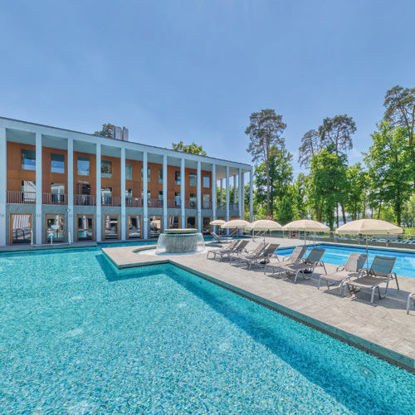 Außenbereich der SaarowTherme mit Thermalsolebecken, Strömungskanal und Sonnenliegen. Entspannende Atmosphäre unter blauem Himmel.