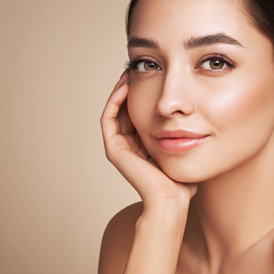 Porträt einer Frau mit der Hand an der Wange und leichtem Lächeln.