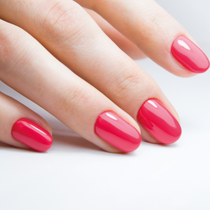 Nahaufnahme einer Hand mit rosa lackierten Fingernägeln.