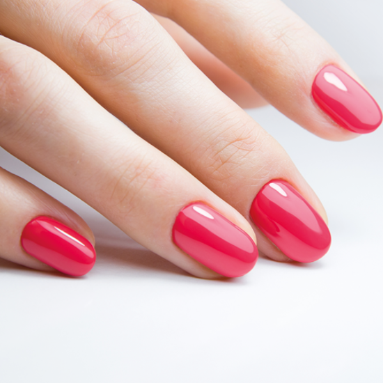 Nahaufnahme einer Hand mit rosa lackierten Fingernägeln.