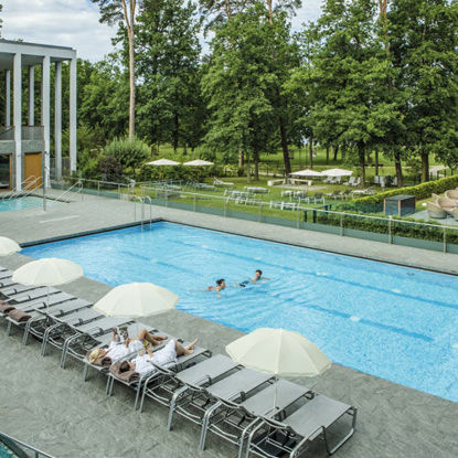Schwimmbecken, Liegen am Beckenrand, Sonnenschirme und der Blick auf den Kurpark